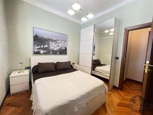 Prostorná ložnice s parketovou podlahou, vestavěné skříně a moderní nábytek nabízejí elegantní a útulný prostor pro odpočinek.