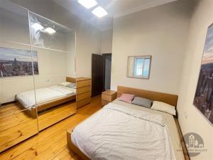 Prostorná ložnice s parketovou podlahou, vestavěné skříně a moderní světlé stěny poskytují elegantní a vzdušný pocit.