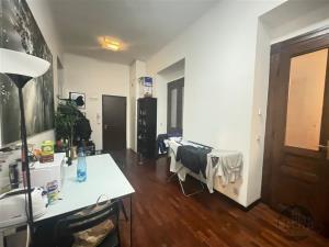 Světlá vstupní chodba s parketovou podlahou, dřevěnými dveřmi a moderním nábytkem, vhodná pro praktické využití a příjemný vstup.